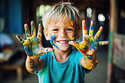 Im Kindergarten wird das Stottern eines Kindes oft zuerst bemerkt. Ein blonder Junge, zirka vier Jahre alt, streckt seine mit Farbe bekleckerten Hände in die Kamera.