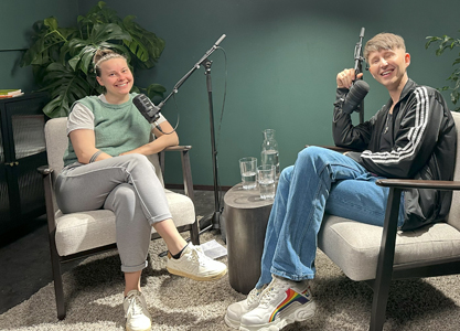 Sprechpause - Der Talk mit Stottern heißt der BVSS-Videopodcast Eine junge Frau und ein junger Mann sitzen auf Sesseln in einem Podcast-Studio.